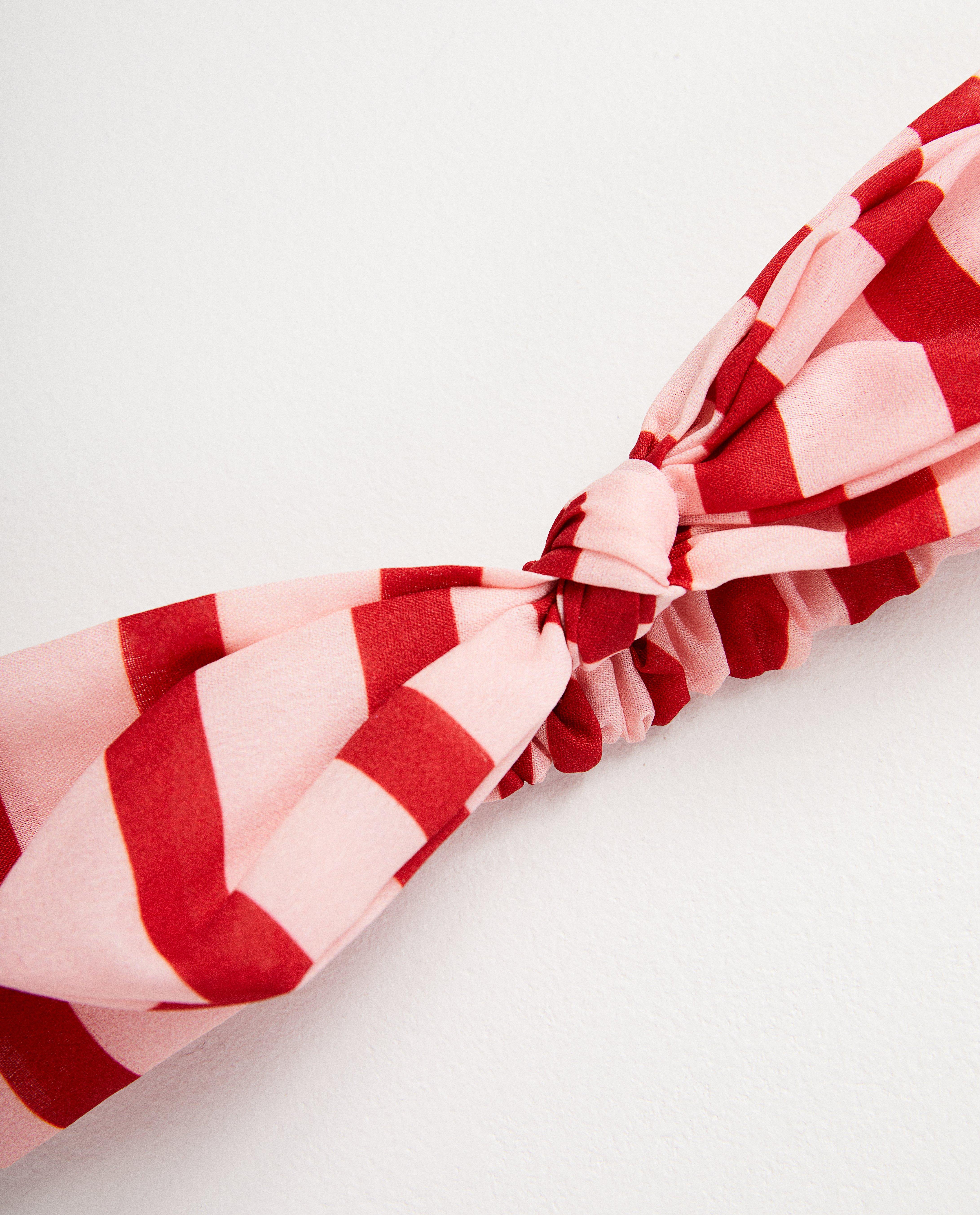 Bonneterie - Bandeau rose avec nœud papillon.