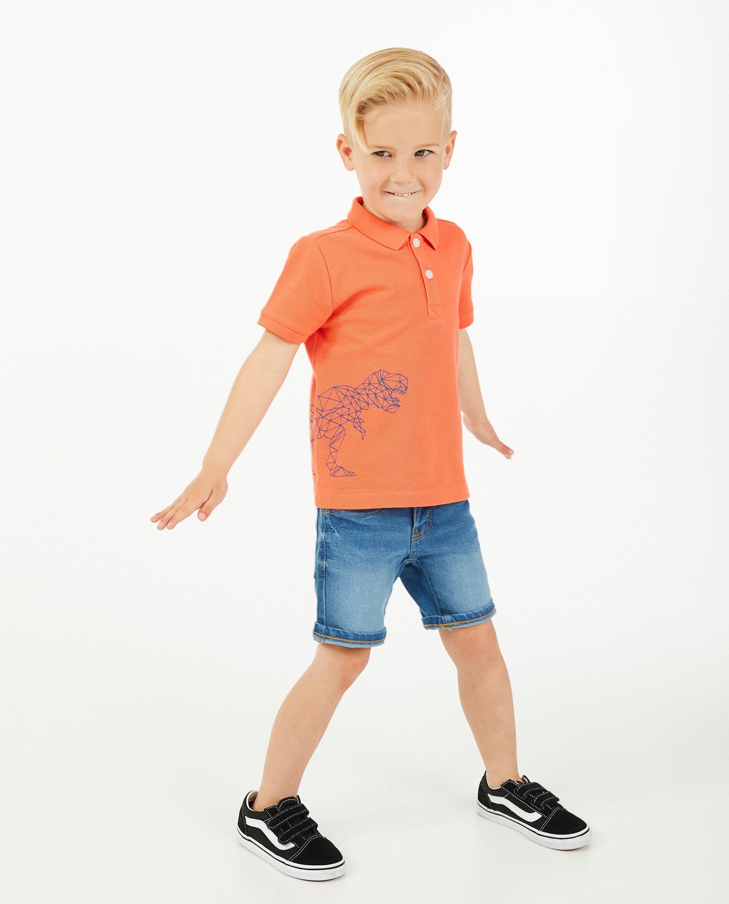 Polo orange avec un imprimé à dinos - sur le côté - Kidz Nation